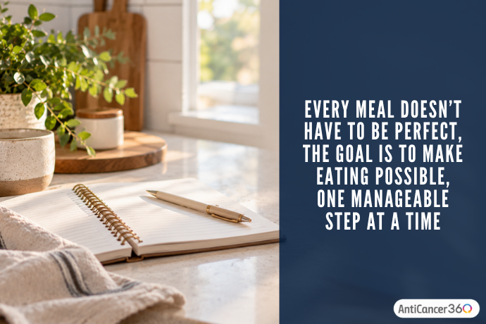 Open notebook and pen on a sunlit kitchen counter beside text encouraging manageable, imperfect steps to make eating easier during appetite loss.